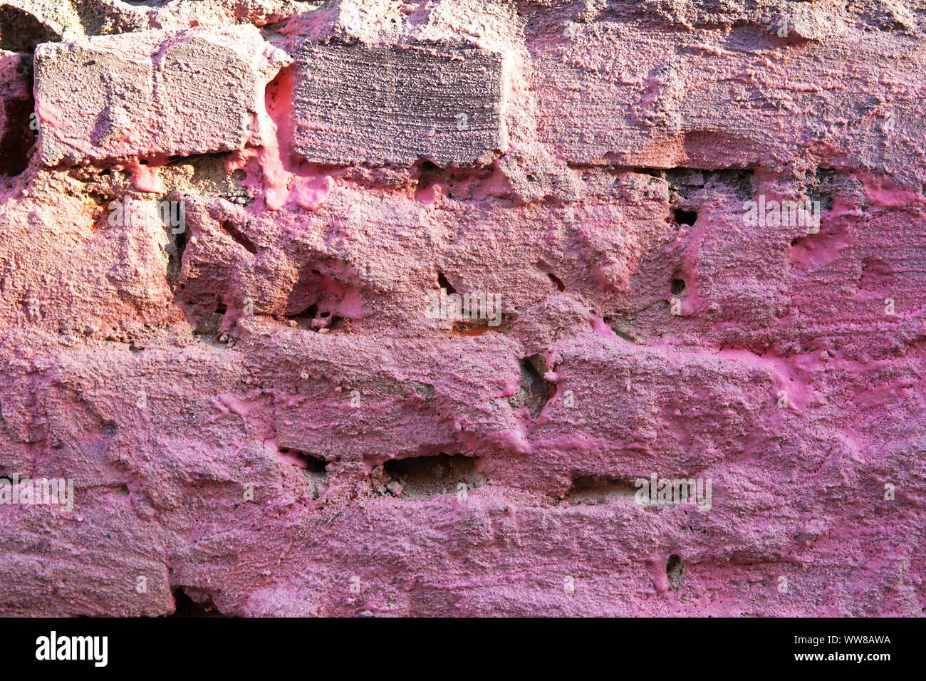 Crumbling painted pink brick wall texture. Backround. Stock Photo
