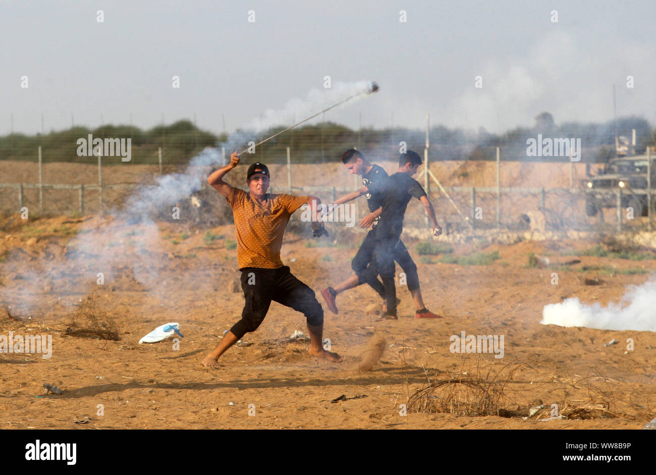 Khan Younis, Gaza. 13th Sep, 2019. A Palestinian protester throws back a tear gas canister fired by Israeli forces during clashes following a demonstration along the border with Israel east of Khan Yunis in the southern Gaza, on Friday, September 13, 2019. 29Palestinians wounded by the Israeli army, a medical source said. Photo by Ismael Mohamad/UPI. Credit: UPI/Alamy Live News Stock Photo
