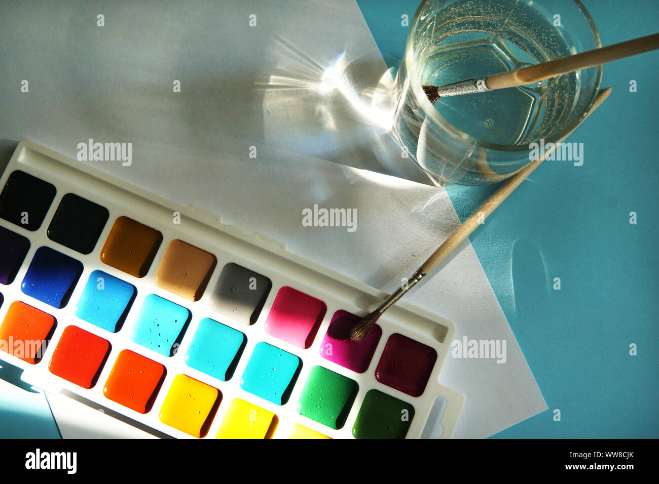 Workplace of an watercolor artist-painter. Blue background, new beautiful paints and brashes. Stock Photo