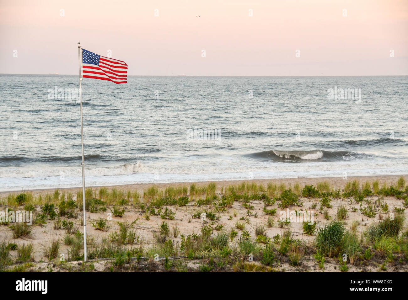 US Flag flying over Dewey Beach at sunset Stock Photo