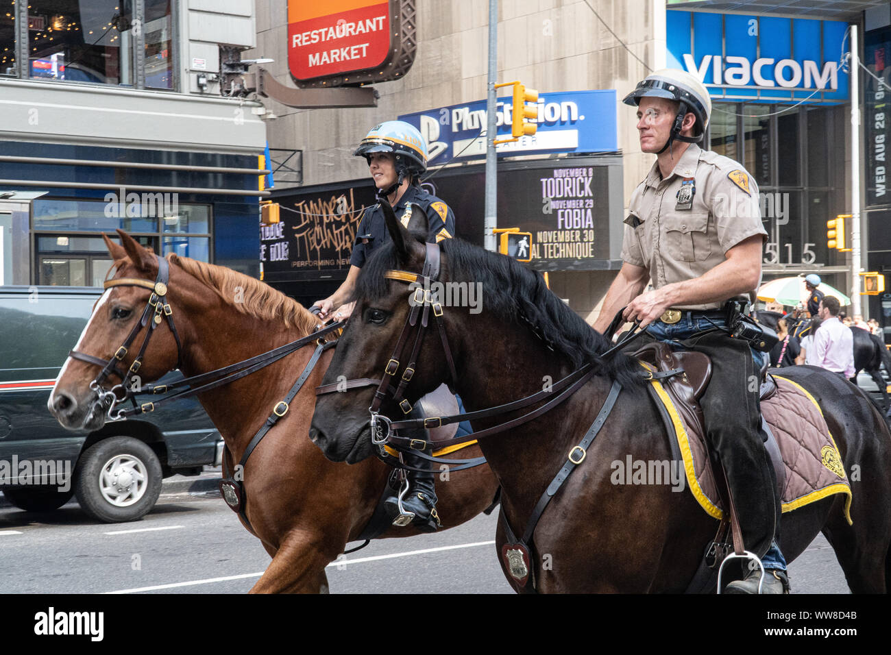 Two Police Officers can be seen on horses in Time Square, New York City ...