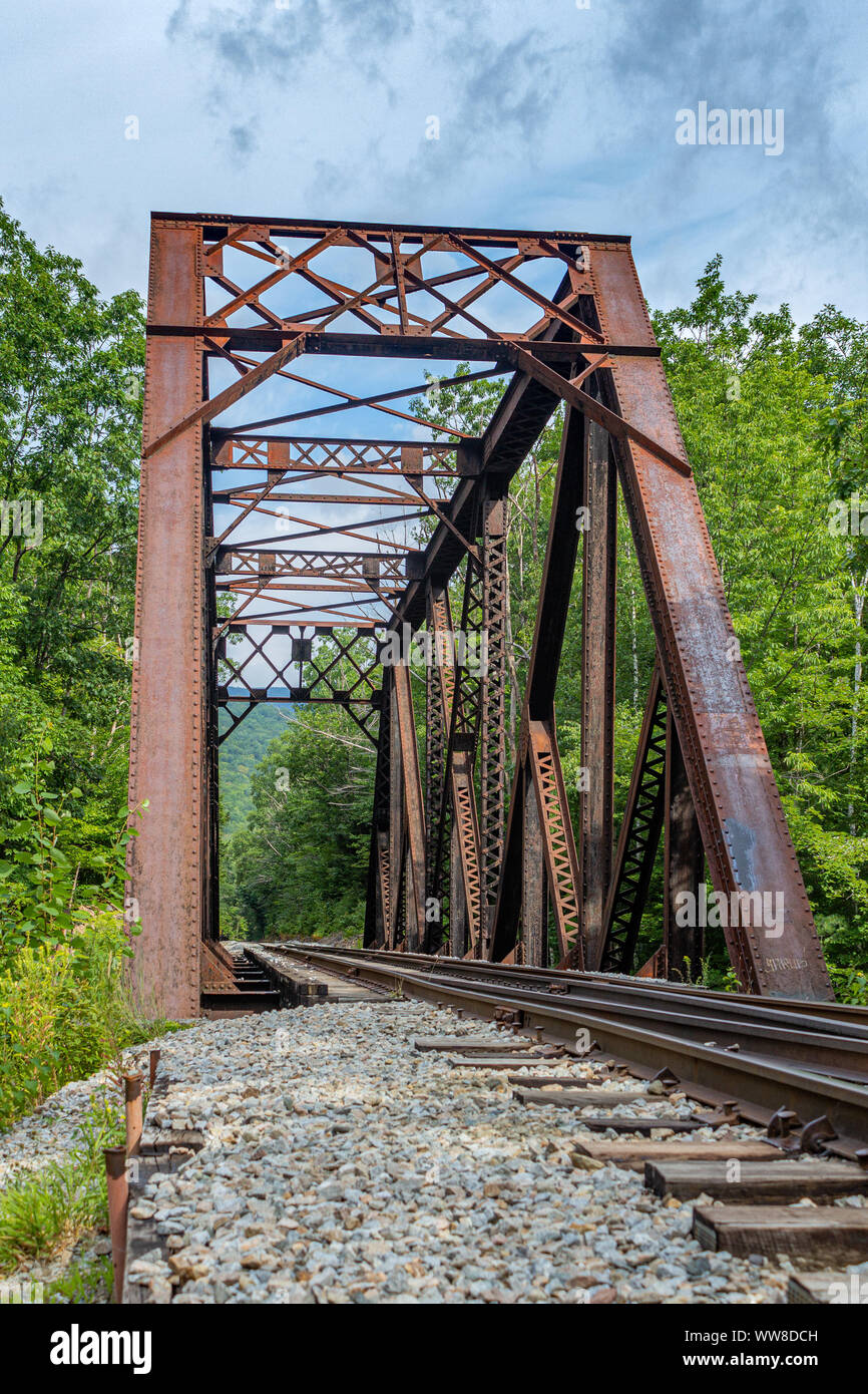 Abandoned railroad tracks under an old iron trestle running to nowhere