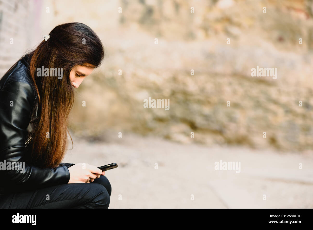 Sad teenage girl feeling lonely, looking at smartphone reading ...