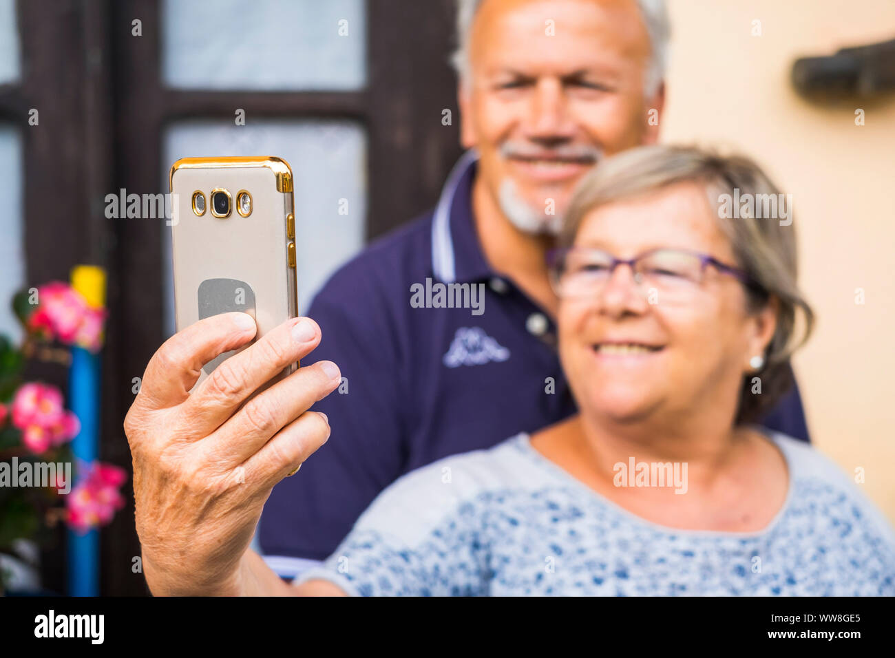 Happy elderly senior couple use mobile phone for taking a picture, modern use of technology from old adult that enjoyed life Stock Photo