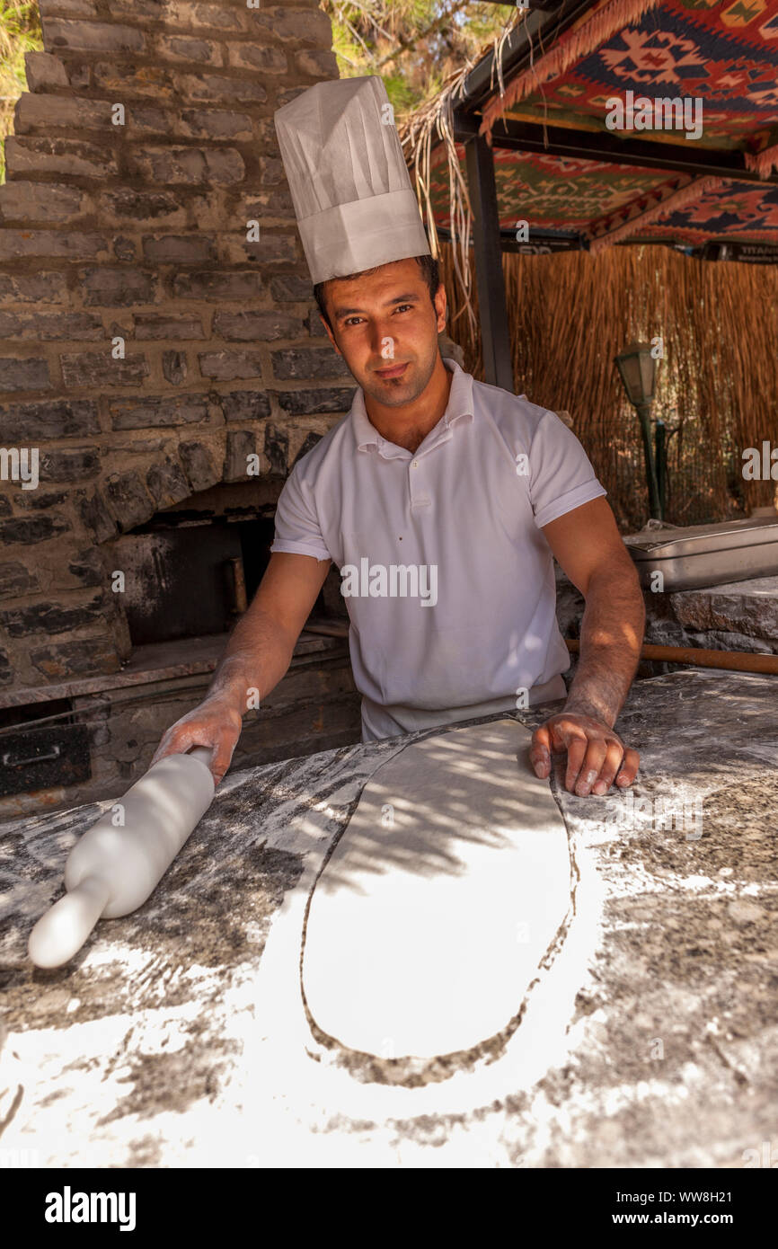 Turkish pide baker baking pide for tourists at an outdoor kitchen at the beach, Near Bodrum, Turkish Riviera, Turkey, Eurasia, Stock Photo