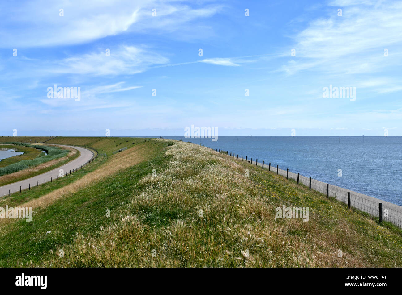view from a dike with the land on the left and the Northsea on the right Stock Photo