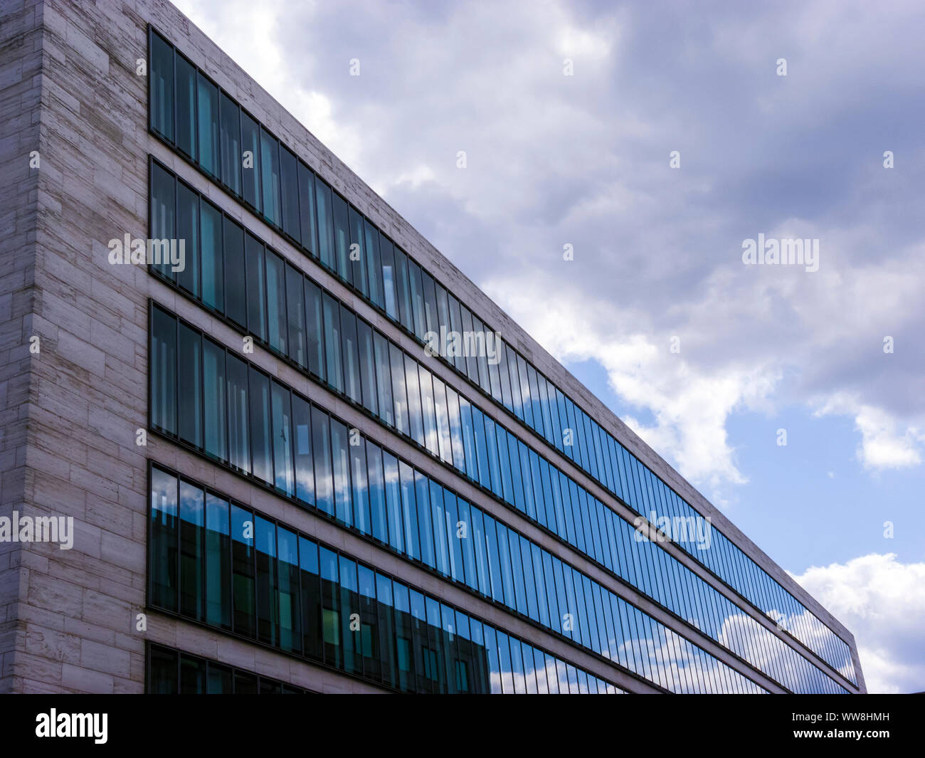 Cloudy sky reflected in the glass wall of a high building Stock Photo ...