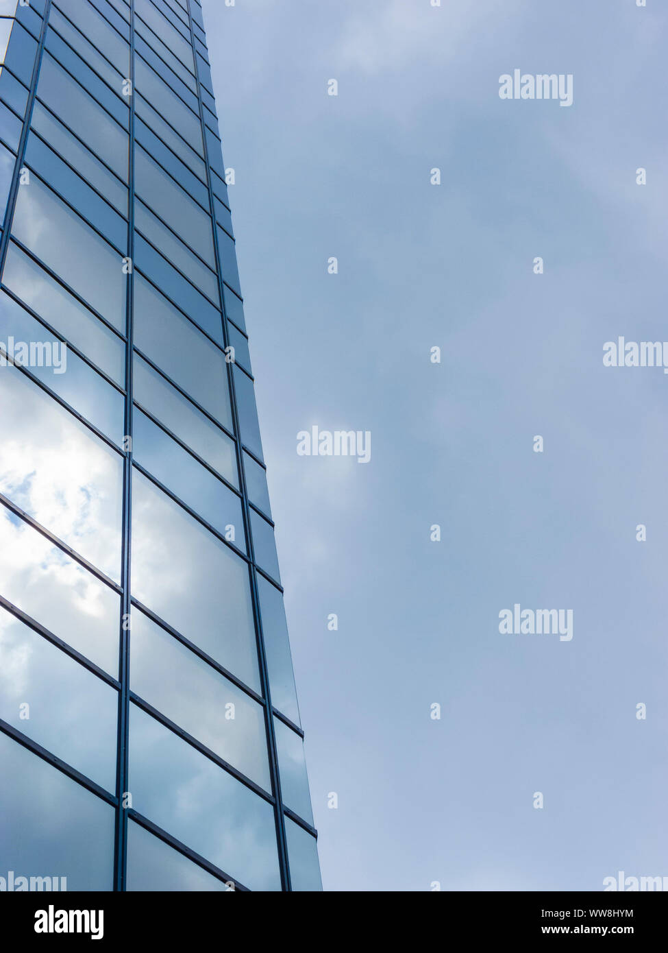 Cloudy sky reflected in the glass wall of a high building Stock Photo ...