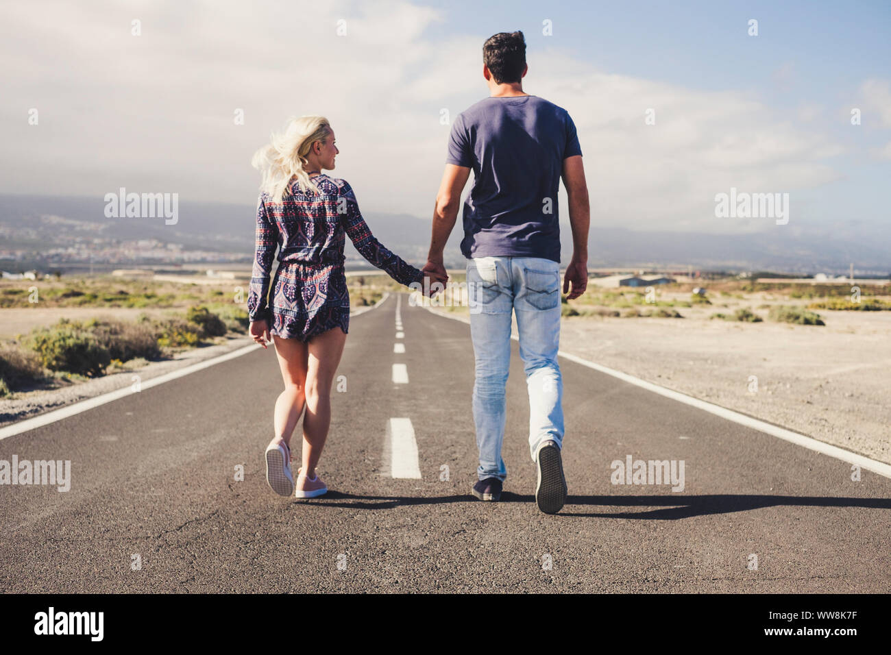 couple of lover in friendship and relationship walk together forever on a long infinite road. travel and life in family concept. team winner and outdoor lifestyle Stock Photo