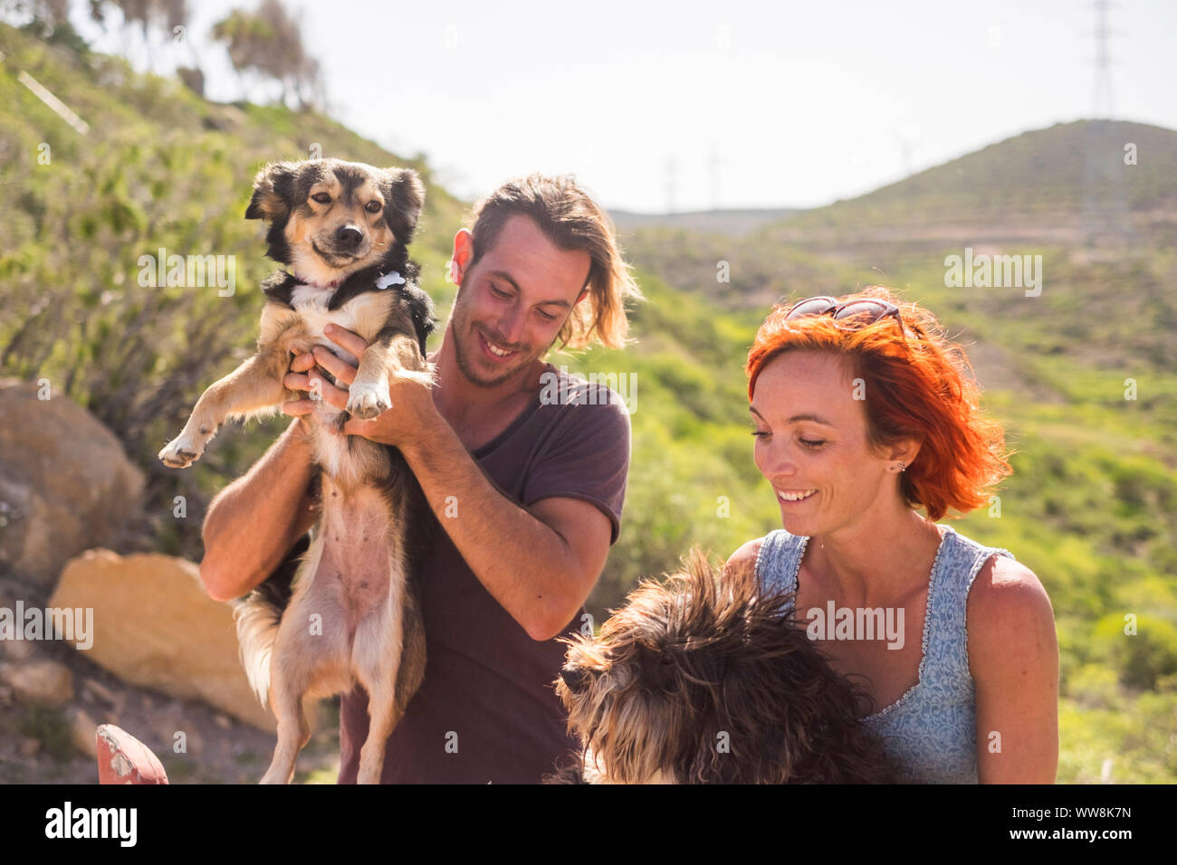 alternative outdoor living lifestyle family and couple in friendship and relationshp have fun with their two dogs. happiness together in outdoor leisure activity. nature country side Stock Photo