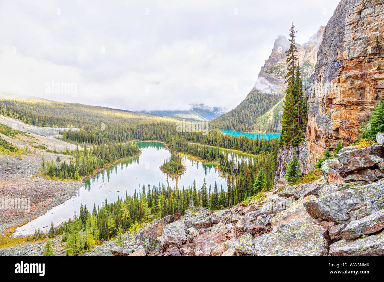 Heavy clouds descend upon Wiwaxy Peaks with Mary Lake and Lake O'Hara as seen from the Opabin Trail in the Canadian Rockies of Yoho National Park in B Stock Photo