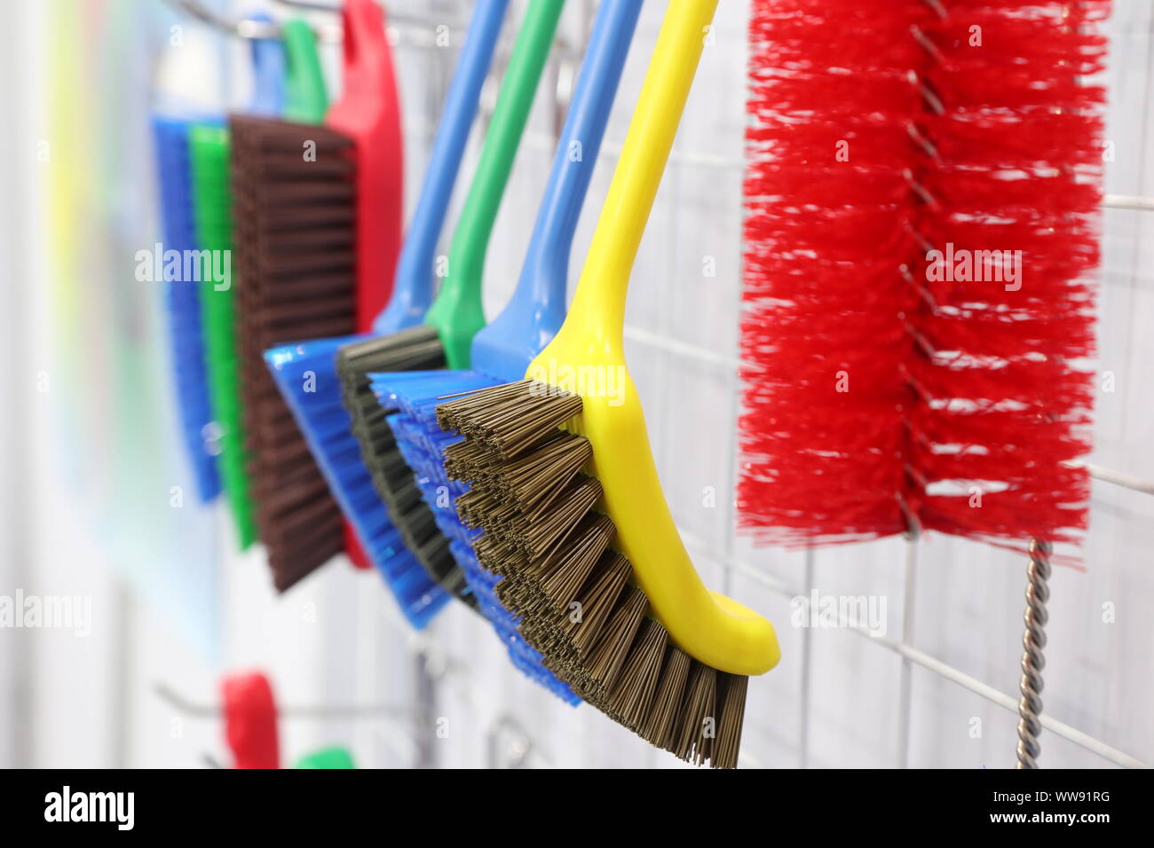 plastic cleaning brushes in supermarket hanger ; close up Stock Photo