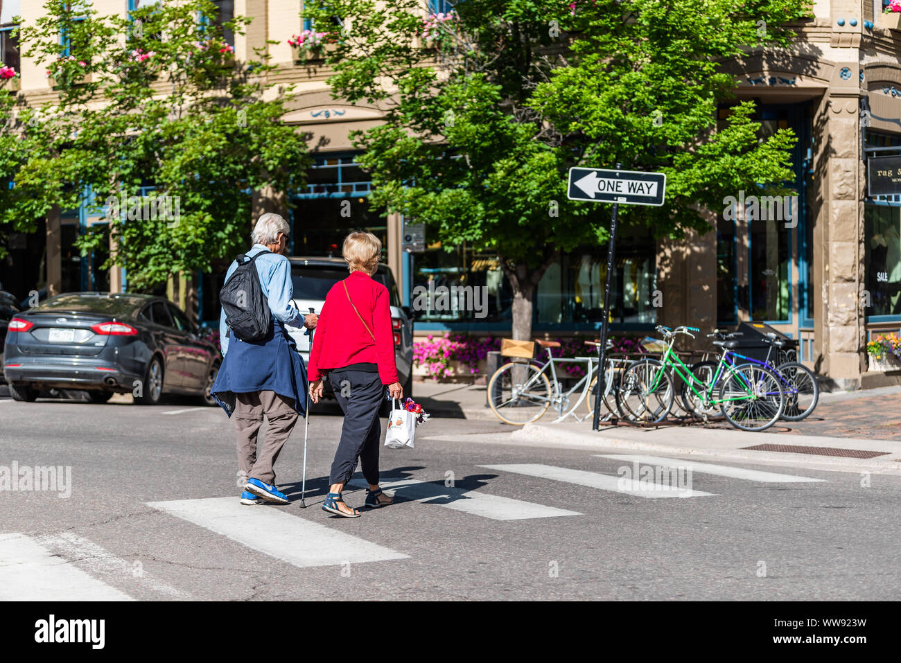 Aspen, USA - July 6, 2019: People older couple crossing street in historic downtown outdoor summer street in Colorado Stock Photo