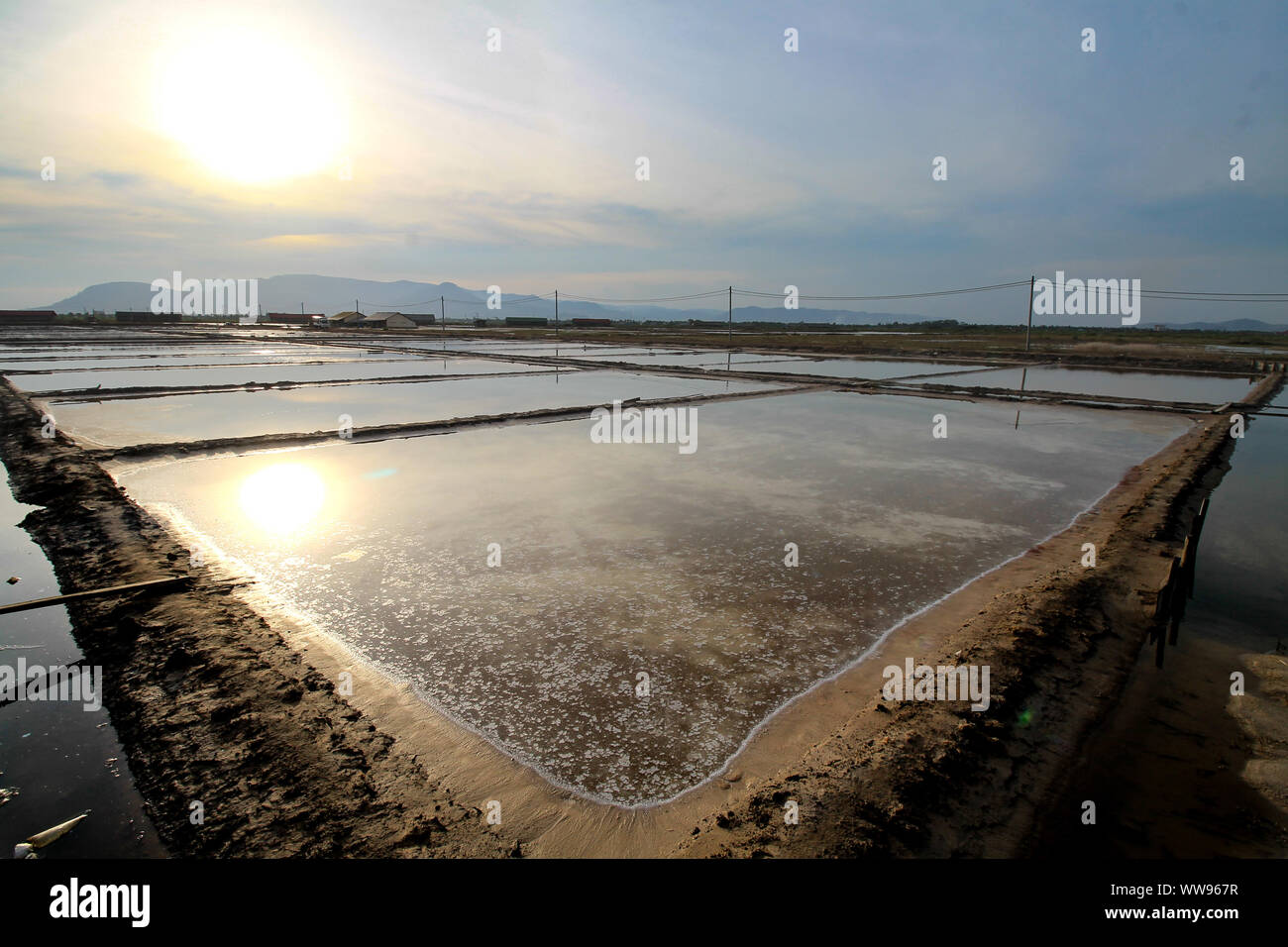 Vast salt farm in the countryside of Kampot Cambodia during a hot tropical summer sunset, candid rural life and livelihood Stock Photo