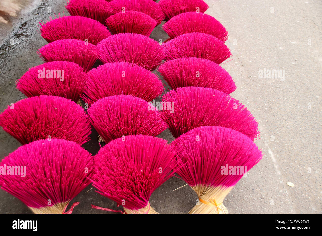 Bundles of boldly colored hand-crafted incense sticks left to dry in the sun at the famous Thuy Xuan Incense Village in Hue, Vietnam Stock Photo