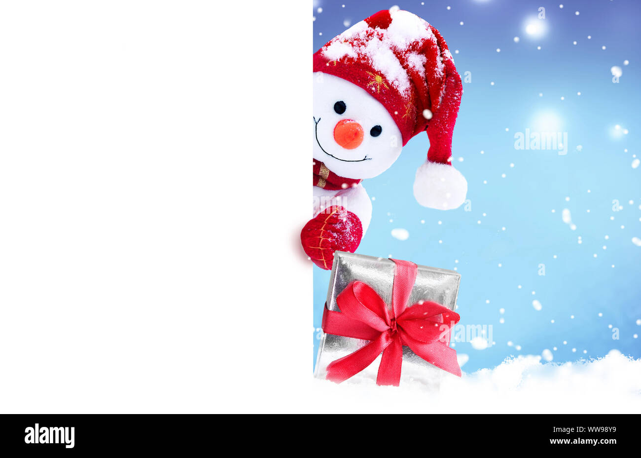 Cute funny snowman holding white page, greeting Christmas card Stock Photo