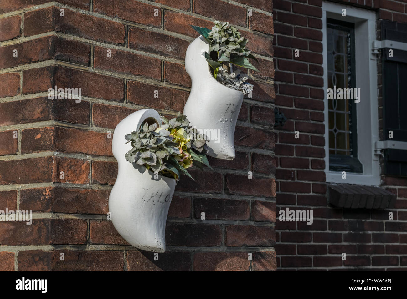 Dutch wooden clogs with flowers on the wall of a house Stock Photo