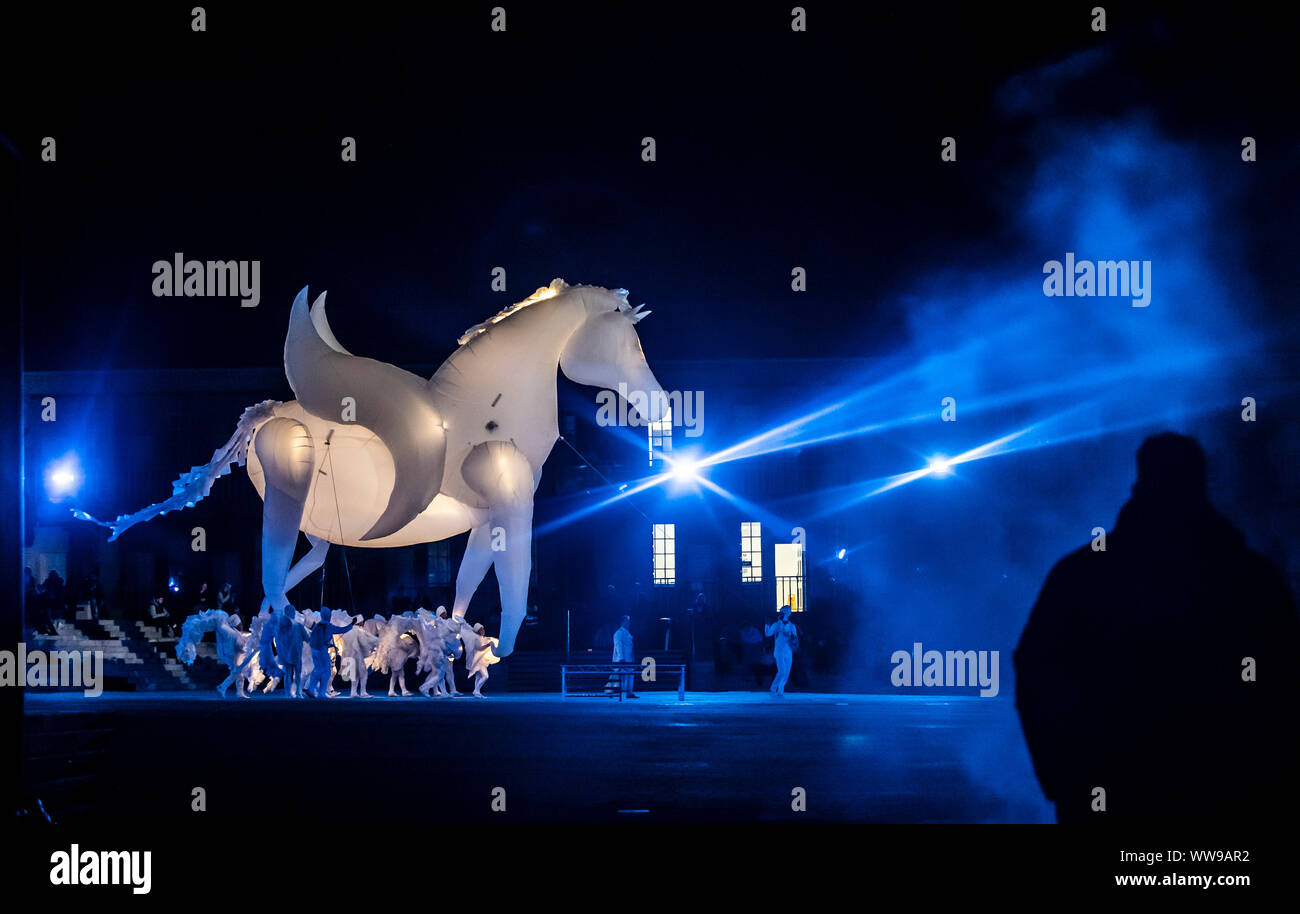 Inflatable glowing white horses perform during arts production FierS a Cheval at the Grade I listed Piece Hall, in Halifax, Yorkshire. Stock Photo