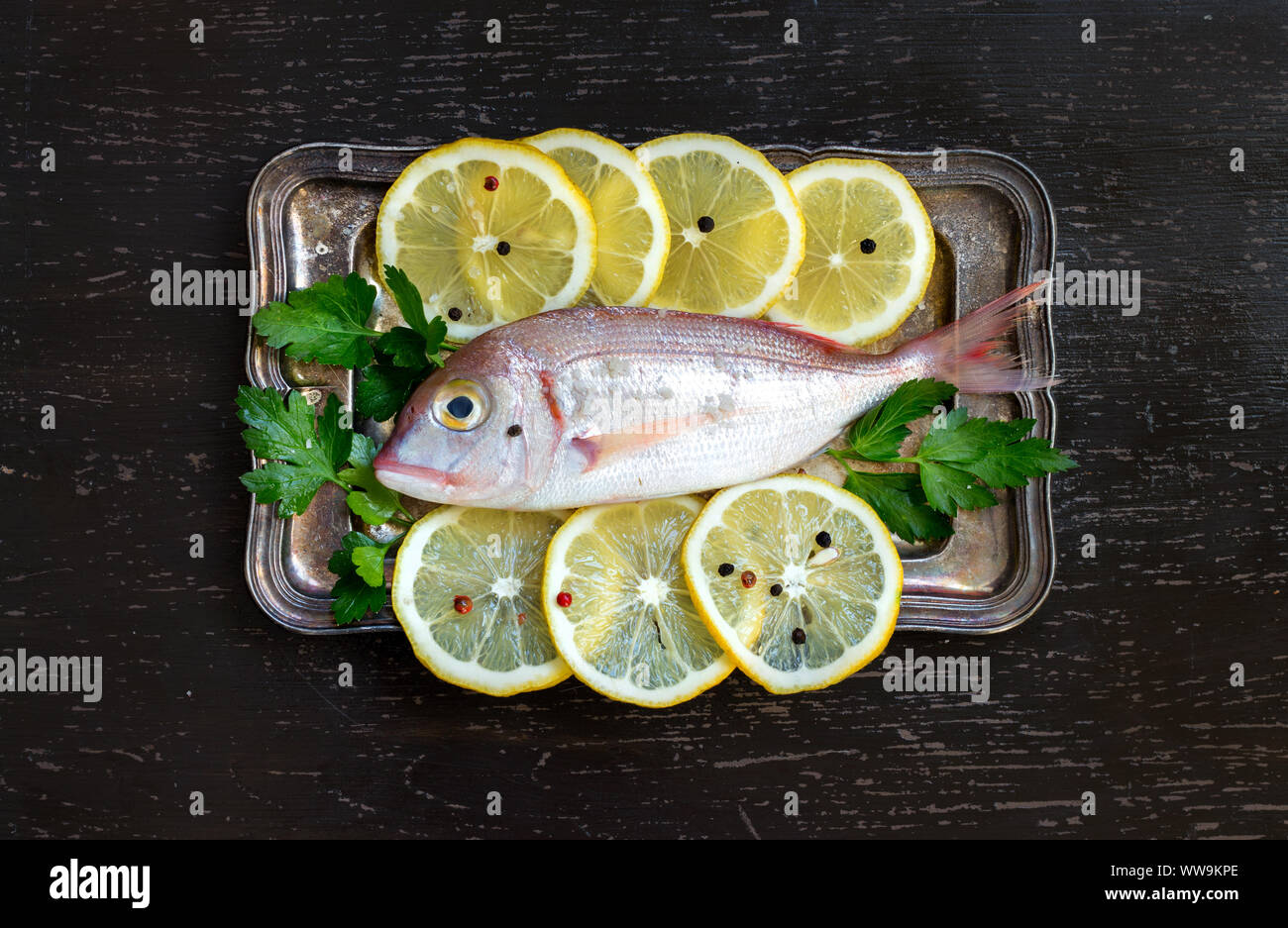 Fresh fish with lemon on vintage silver tray Stock Photo