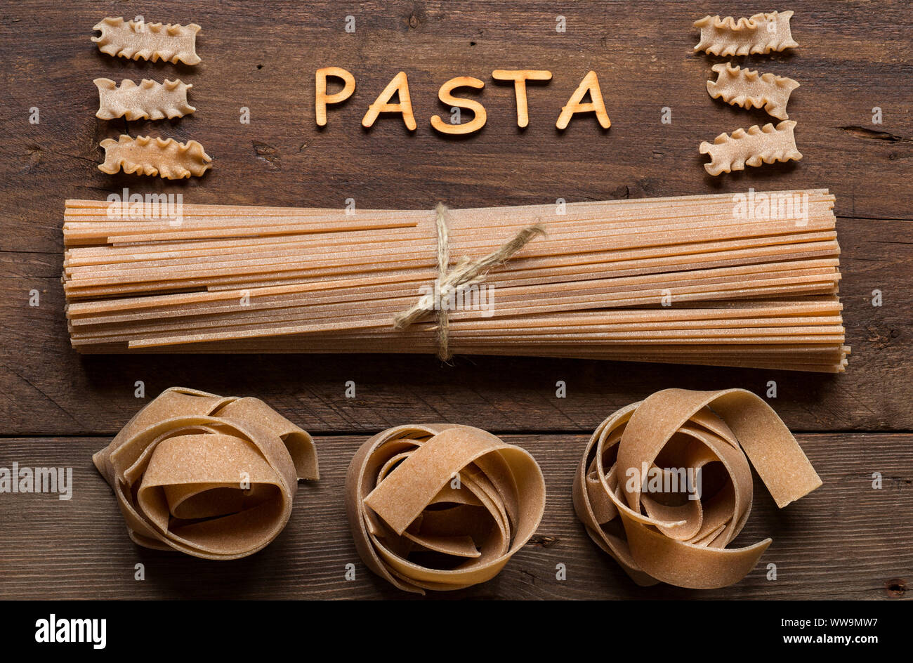Whole wheat italian pasta and word Pasta on wood Stock Photo Alamy