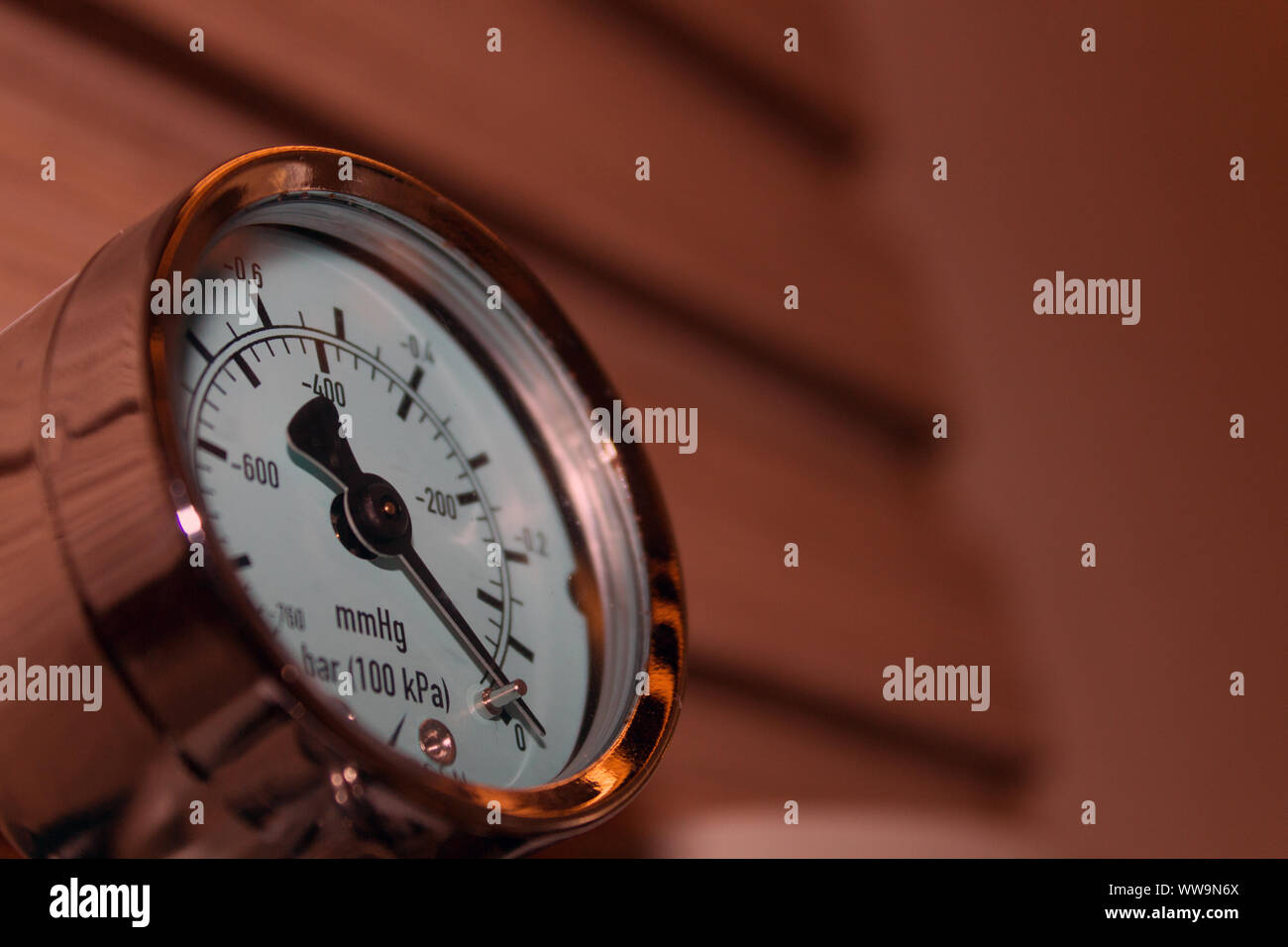 Close up of a pressure gauge indicating level zero, mounted on a wall, elegantly made case