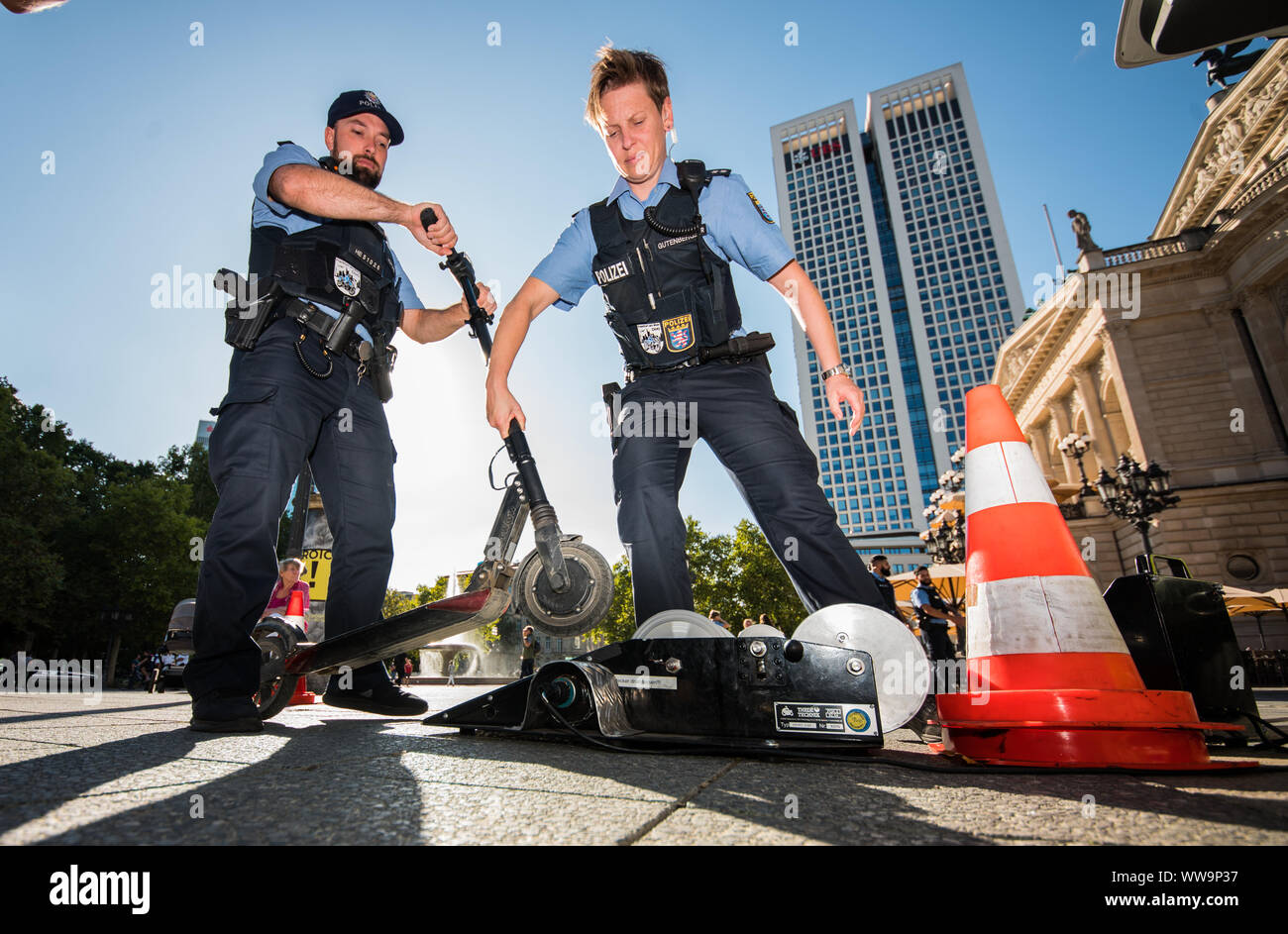 04 September 2019, Hessen, Frankfurt/Main: Policemen check an e-scooter on  the chassis dynamometer. Police officers check e-scooters in front of the  Alte Oper. According to police reports, an electric pedal scooter was