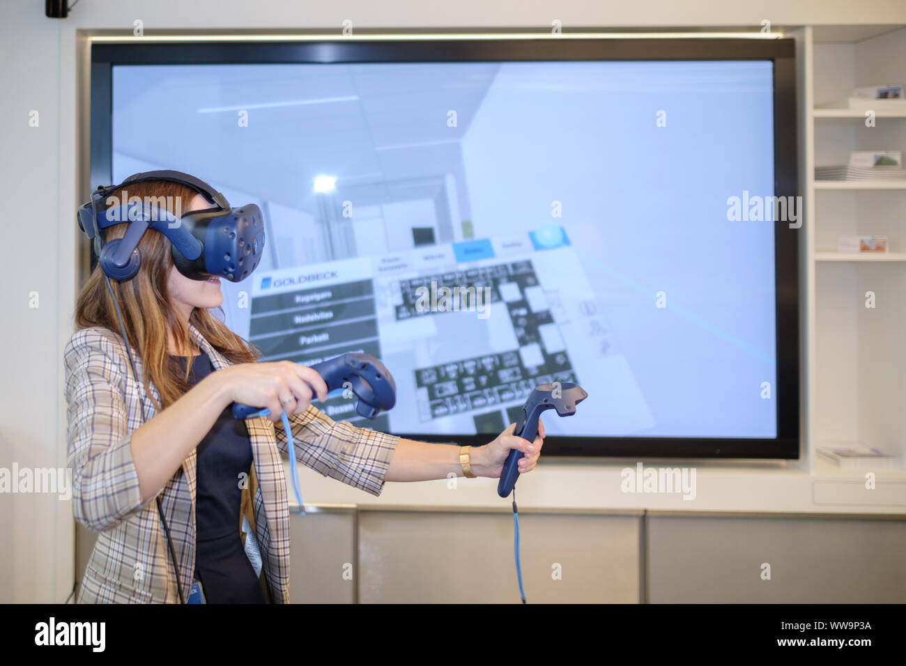 Bielefeld, Germany. 29th Aug, 2019. Katharina Tiemann, architect at Goldbeck GmbH, leads through an office configurator with virtual reality glasses. Altmaier visits medium-sized companies in Lower Saxony and North Rhine-Westphalia during his three-day trip. He had been heavily criticised by trade associations, partly because small and medium-sized enterprises had hardly played a role in his industrial strategy. Credit: Ole Spata/dpa/Alamy Live News Stock Photo