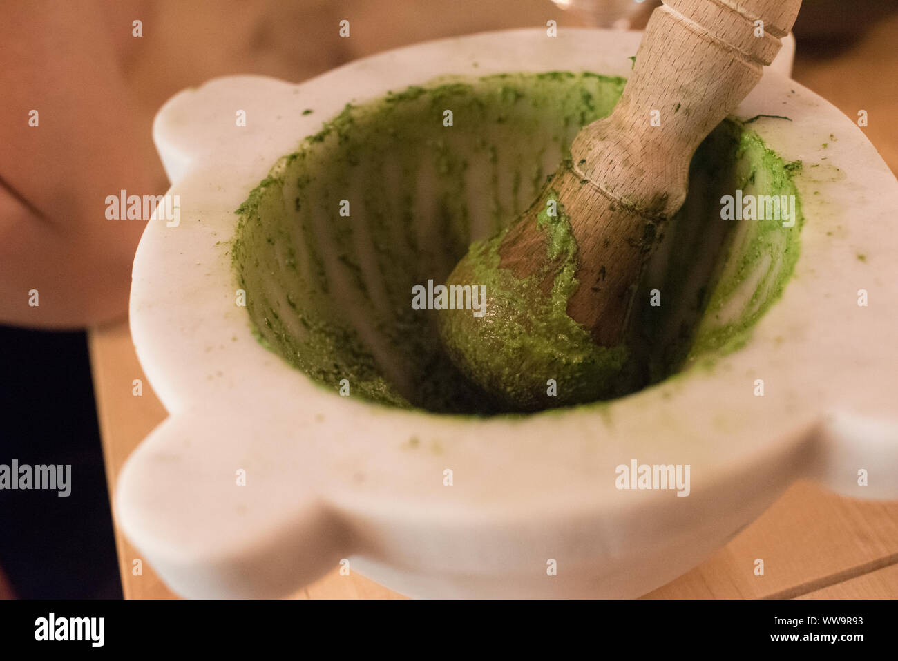 Riomaggiore, Italy - July 2, 2018: A mortar and pestle being used to make bright green pesto in Cinque Terre, the five small fishing villages along th Stock Photo