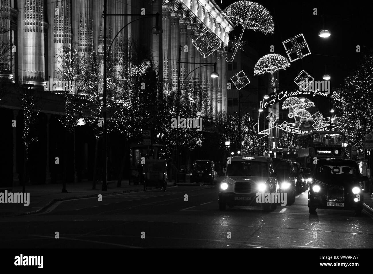 London at night with London black Taxi cabs,  the Oxford street Christmas lights and Selfridges store. Authentic imagery. night scene in London's West end. W1. Postal district. Stock Photo