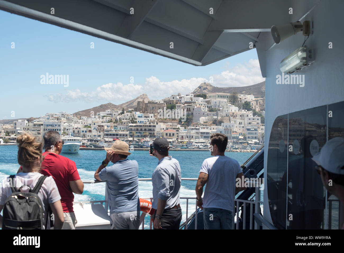Naxos, Greece - June 28, 2018: The town of Naxos in the distance as a ferry pulls out of the Port of Naxos. Stock Photo