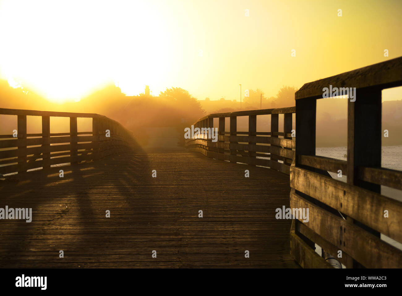 footbridge in the mist at early morning sunrise Stock Photo