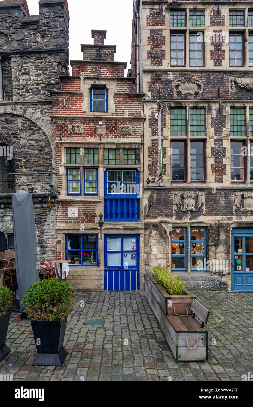 The tiny Tolhuisje (House of Tonlieu) with bright blue door and windows. It is the smallest house in Ghent, which stands on the Graslei. Stock Photo