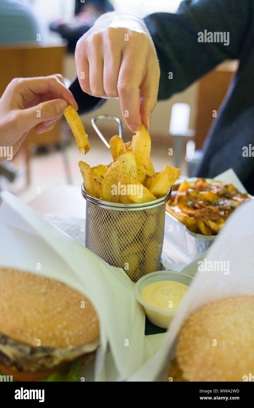 Fast food. Family eating french fries in restaurant Stock Photo - Alamy
