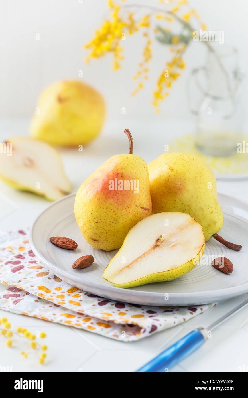 Delicious fresh and ripe Williams pears or Bartlett pears on a plate against light background. Still life shallow depth of field Stock Photo