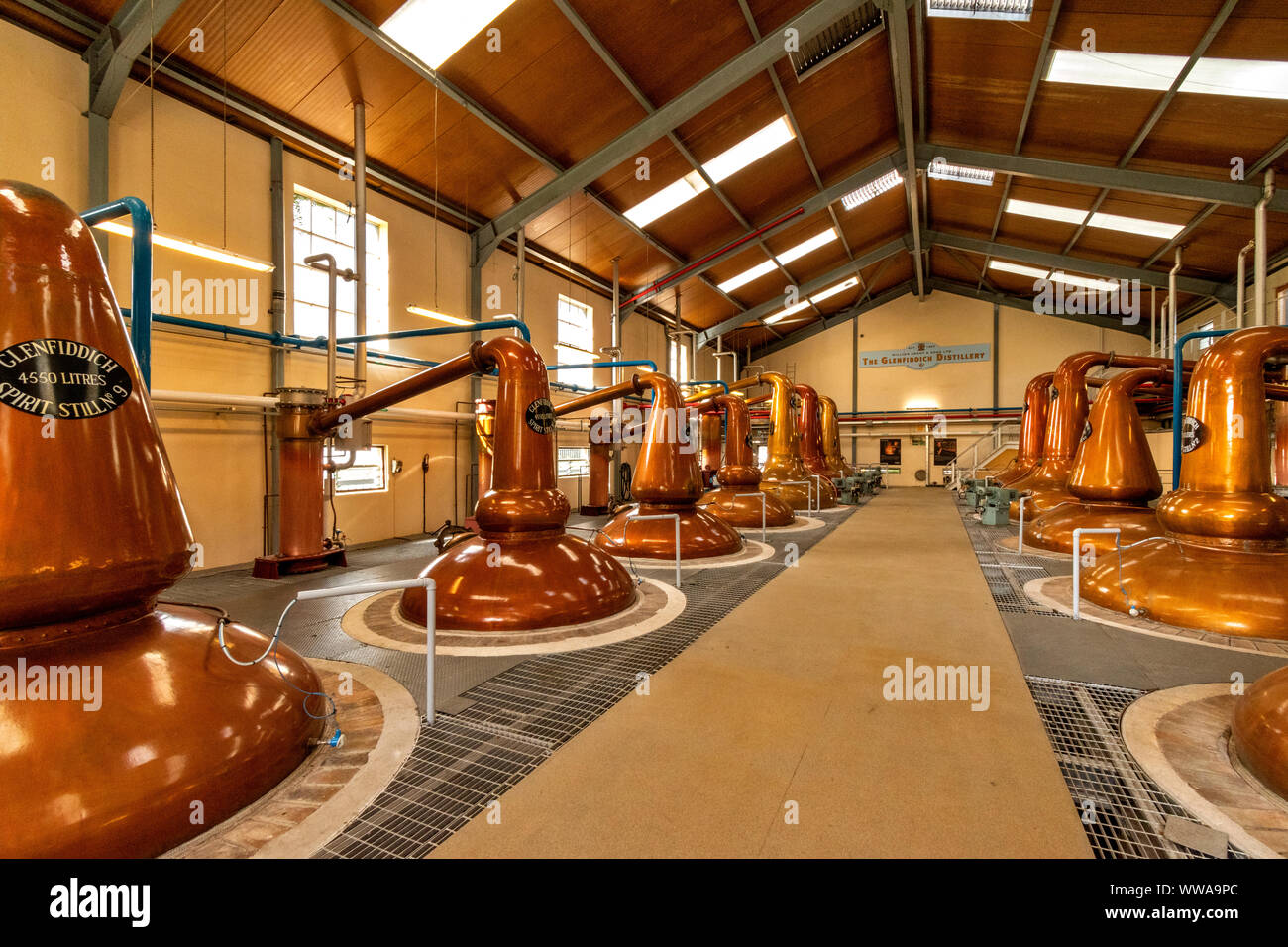 GLENFIDDICH WHISKY DISTILLERY DUFFTOWN MORAY SCOTLAND GLENFIDDICH ROWS OF COPPER POT STILLS  AND SIGN SHOWING THE CAPACITY OF EACH STILL Stock Photo