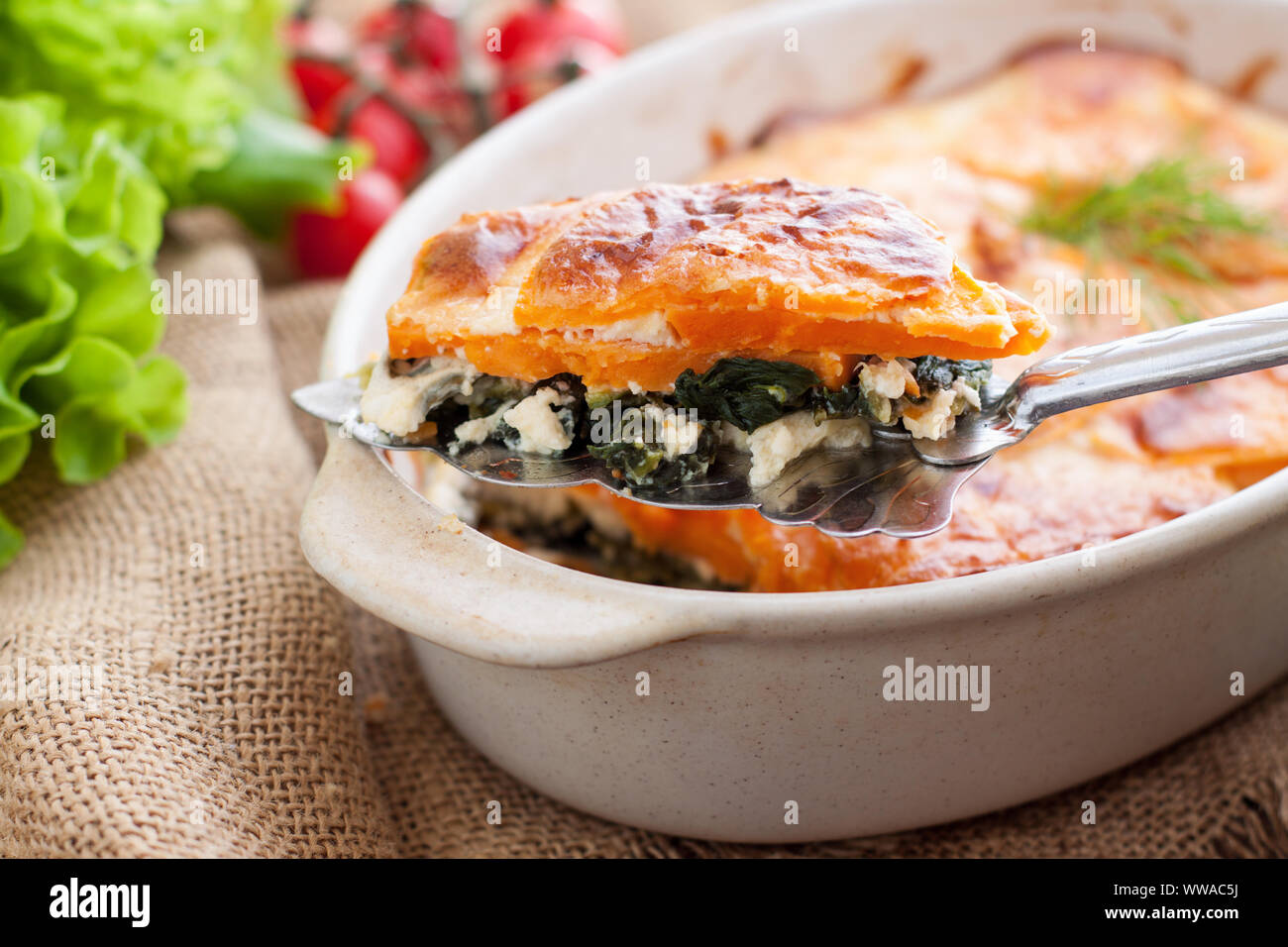 Healthy casserole or gratin with sweet potatoes, spinach, eggs and feta
