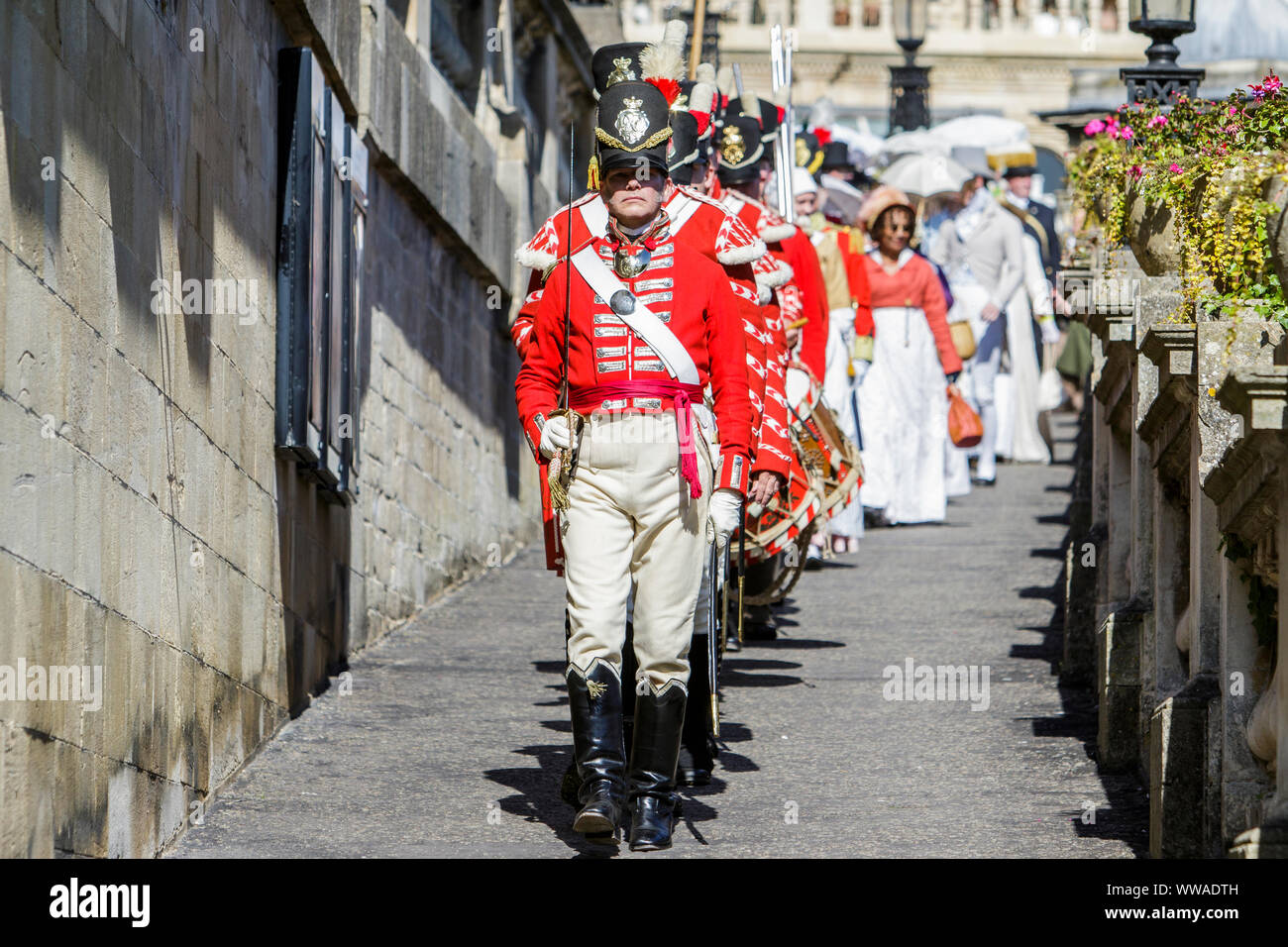 Bath, Somerset, UK. 14 Sep, 2019. Members of the re-enactment group, His Majesty’s 33rd Regiment of Foot taking part in the world famous Grand Regency Costumed Promenade are pictured as they enter Parade Gardens. The Promenade, part of the 10 day Jane Austen Festival is a procession through the streets of Bath and the participants who come from all over the world dress in 18th Century costume. Credit:  Lynchpics/Alamy Live News Stock Photo