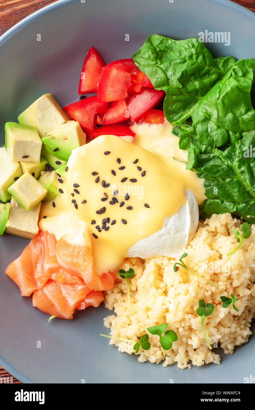 Vegetable buddha bowl with salmon, feta cheese and couscous, spinach