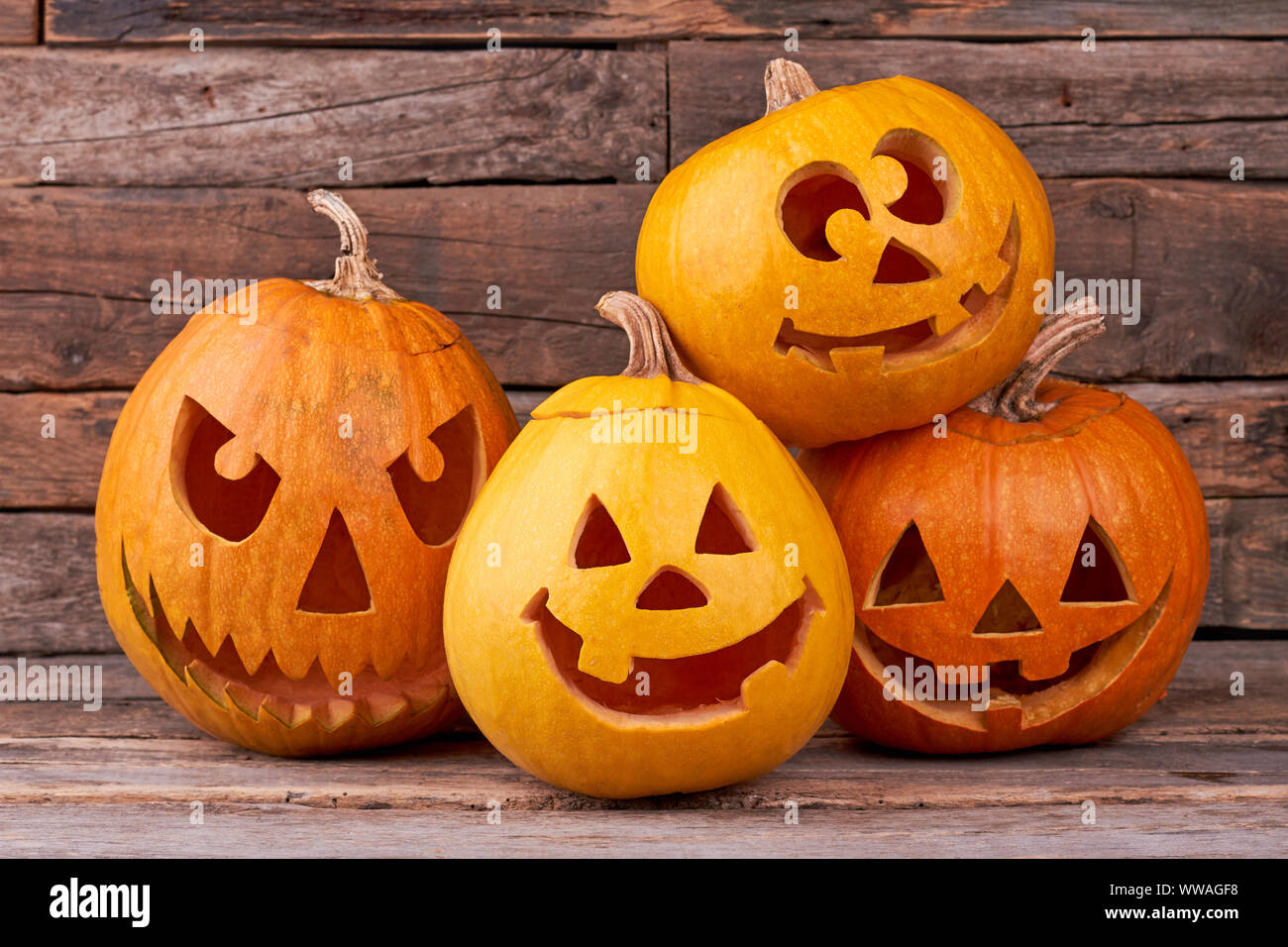 Funny Halloween pumpkins on wooden background. Stock Photo
