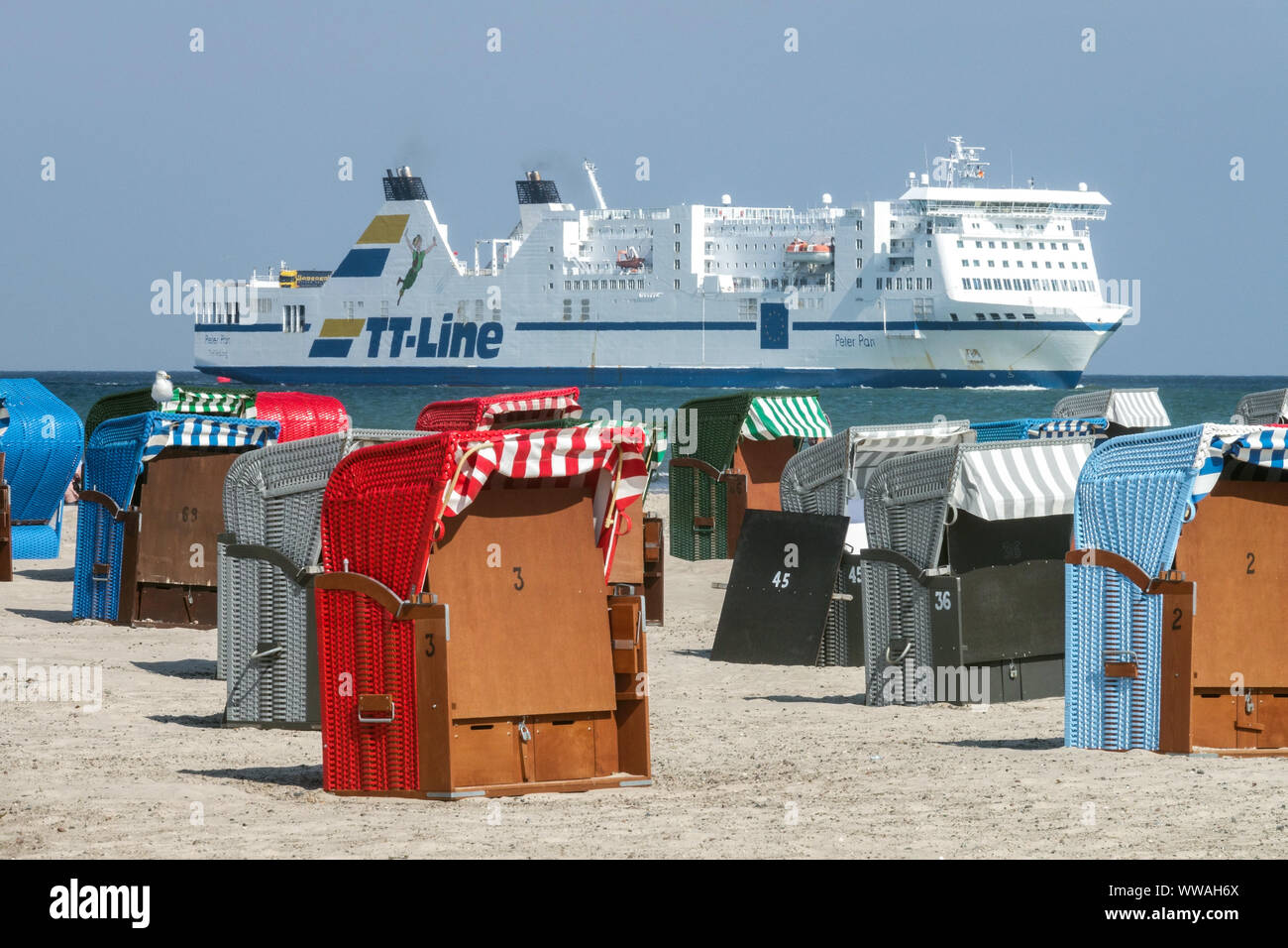 Colorful beach chairs on the beach in Warnemunde, in the background