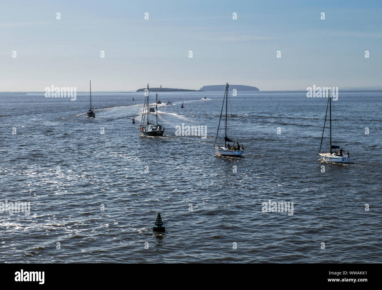 A line or procession of boats entering the Bristol Channel having come through the lock gates of the Cardiff Bay barrage, Stock Photo