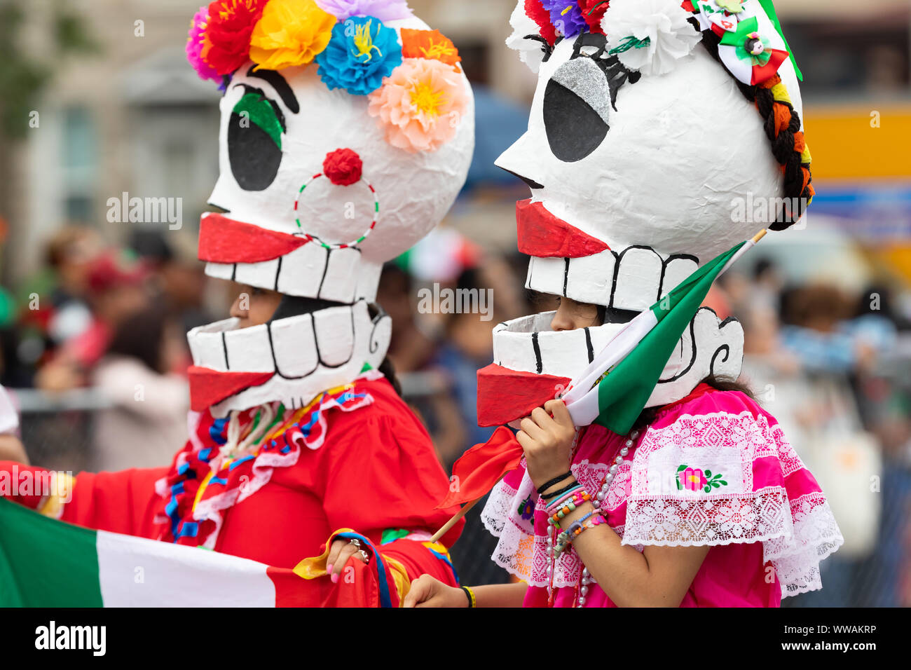 Chicago, Illinois, USA - September 8, 2019: 26th Street Mexican Independence Parade, women wearing traditional clothing, with a skull mask, carrying t Stock Photo