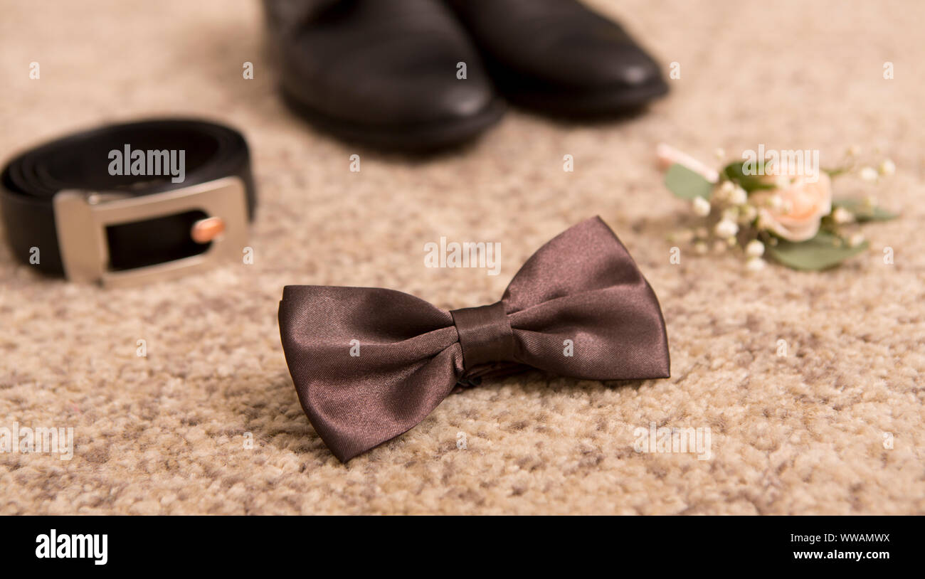 Close up of wedding bow tie, belt and man shoes on floor Stock Photo