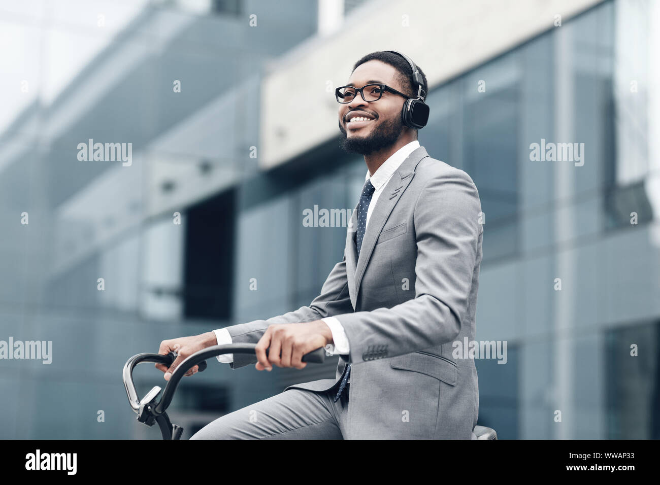 Way to work. Businessman riding on bike to work, listening music Stock Photo