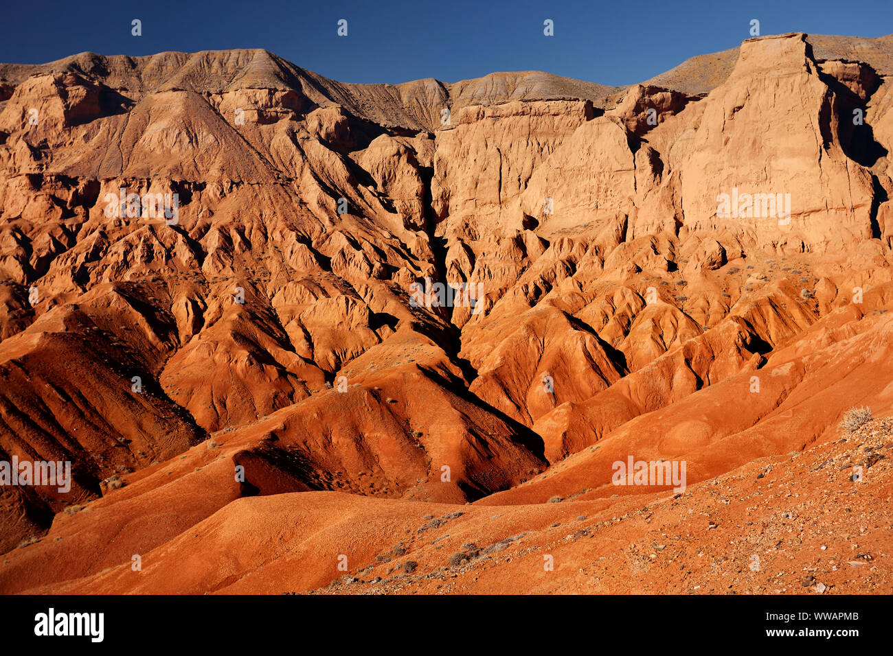 Red mountains in the desert canyon against blue sky in Kazakhstan Stock Photo