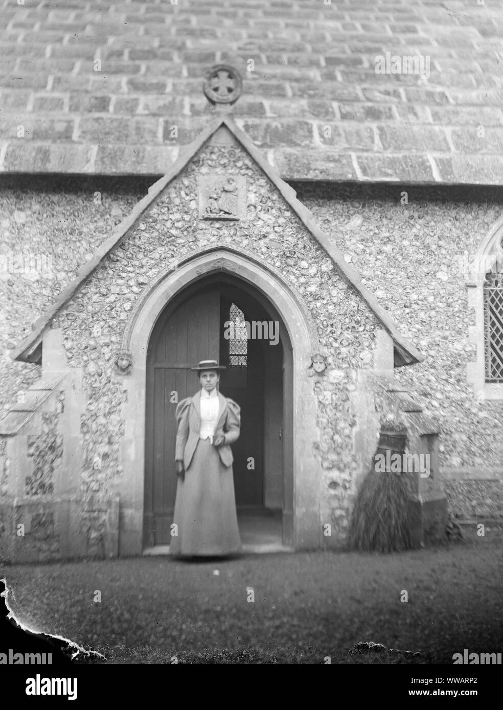 Late victorian or Early Edwardian lady standing in a church doorway Stock Photo