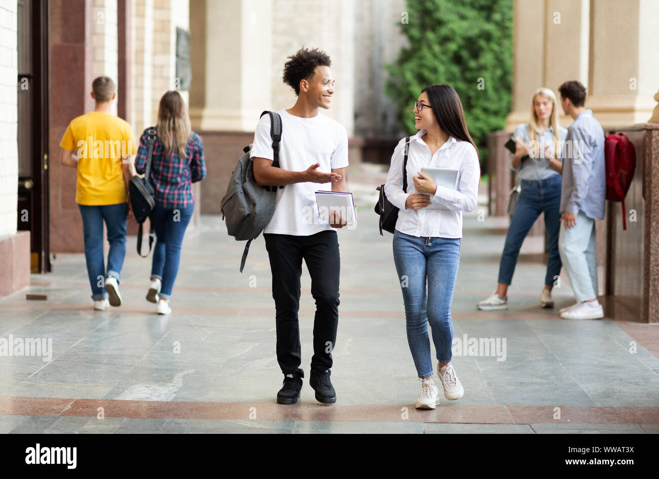 Diverse classmates chatting, walking after classes outdoors Stock Photo - Alamy