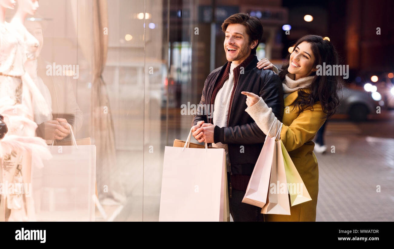 Girl showing man fashion clothes in boutique Stock Photo - Alamy