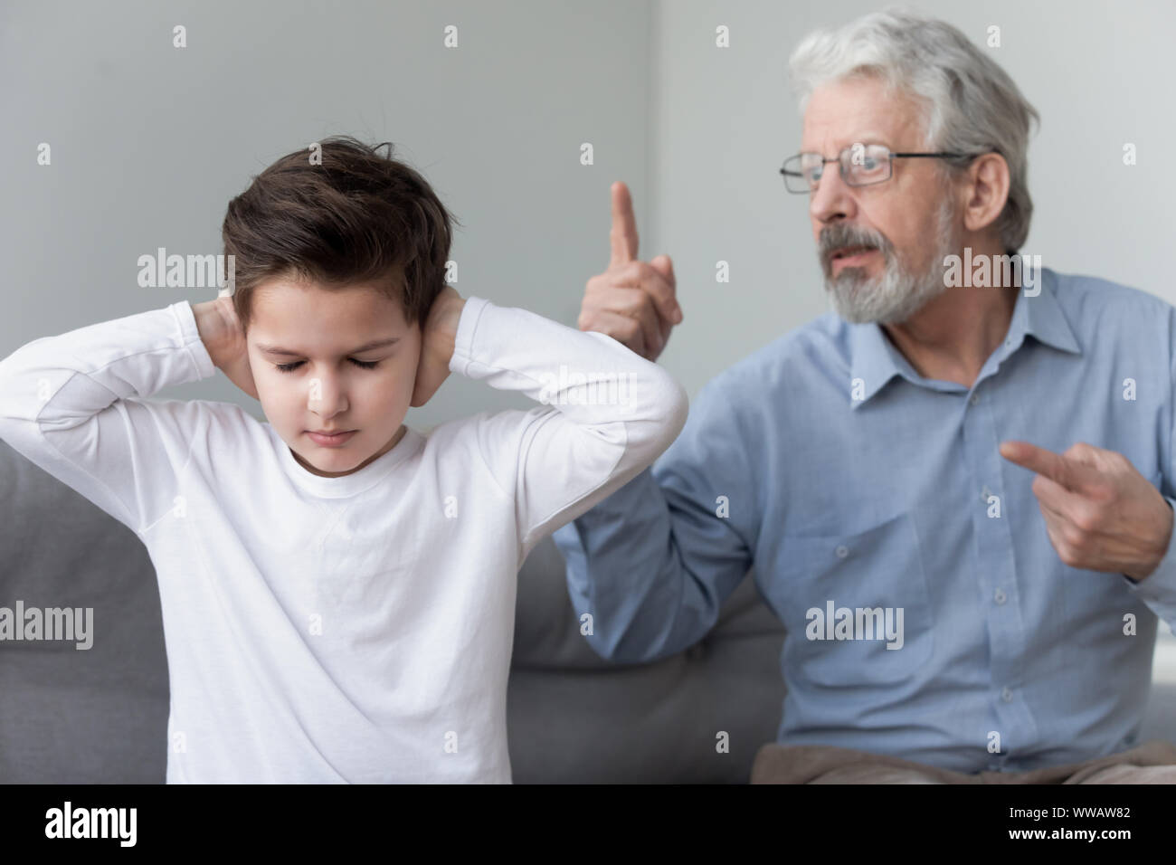 Angry old grandpa shouting at grandson close ears ignore grandfather Stock Photo