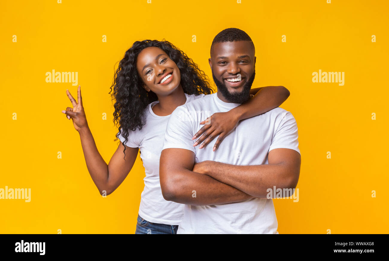 Happy young couple posing over yellow studio background Stock Photo